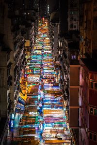 High angle view of illuminated market amidst buildings at night