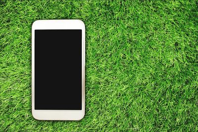 Close-up of smart phone on grass