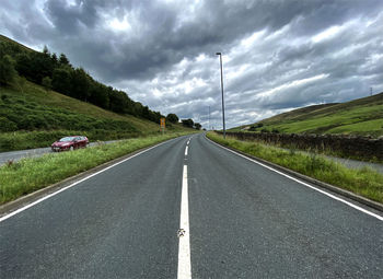 Empty road against cloudy sky on, burnley road near todmorden, uk
