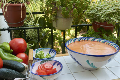 Gazpacho, some ingredient to prepare, a rustic table,  in traditional andalusian glazed ceramic 