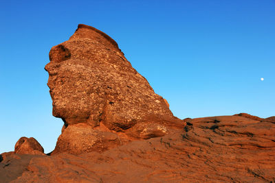 Sphinx rock formation against clear blue sky at bucegi natural park