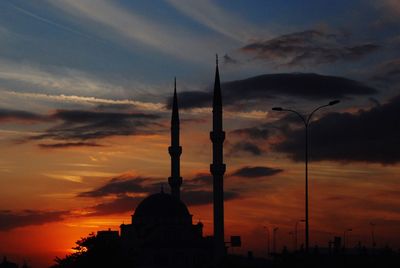 Silhouette minarets against scenic sky