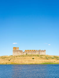 Built structure on beach against clear blue sky