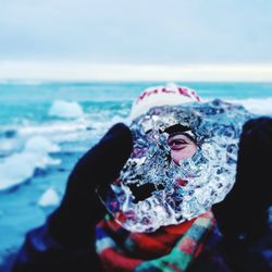 Portrait of woman holding ice at beach