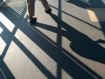 Low section of woman walking on zebra crossing