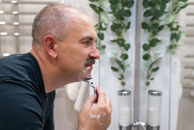 Side view of young man drinking water