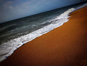 Close-up of beach against sky