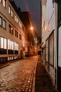 Empty alley amidst buildings in city