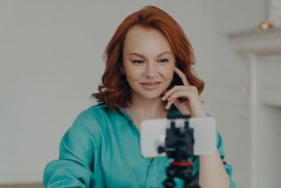 Young woman smiling while blogging at home