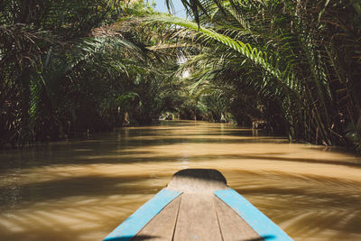 Wooden rowboat in river at forest