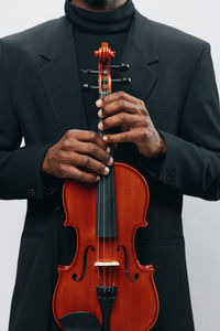 Midsection of man playing violin against white background