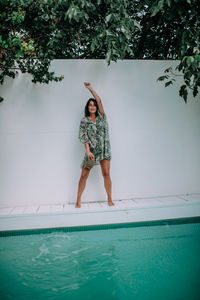 Full length of woman standing by swimming pool