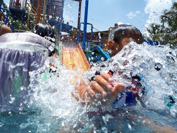 Boy splaying water at park