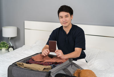 Portrait of young woman using mobile phone while sitting at home