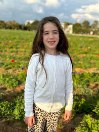 Portrait of young woman standing on field