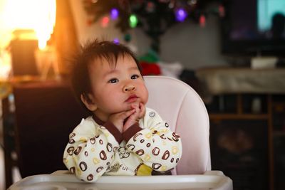 Portrait of cute baby girl sitting at home