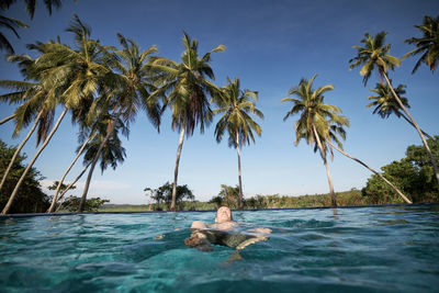 Man swimming in sea against sky