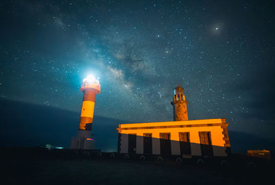 Low angle view of lighthouse against sky at night