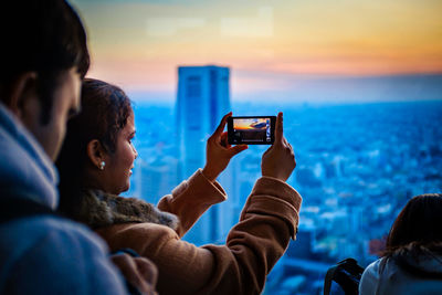 People photographing at sea during sunset