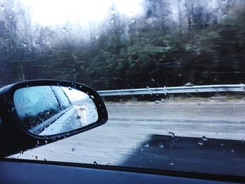 Close-up of wet side-view mirror of car