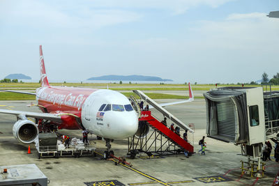 Airplane on airport runway against sky