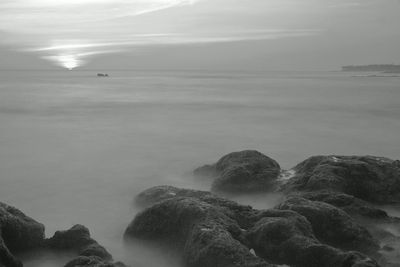 Rocks on sea shore against sky