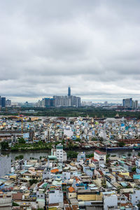 High angle view of buildings in city against cloudy sky