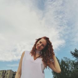 Portrait of beautiful woman standing against sky