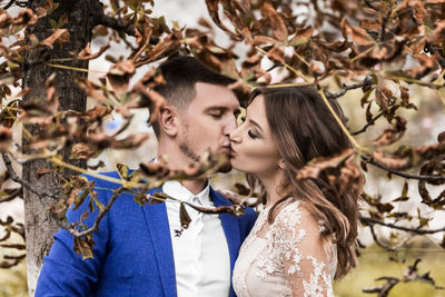 Young couple kissing on leaves