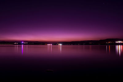 Scenic view of lake against sky at night