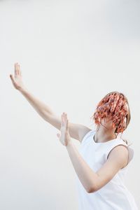 Teenage girl with shrimps on face standing against white background