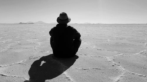 Rear view of man at salar de uyuni on sunny day