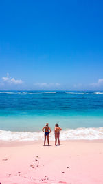 Friends on beach against sky