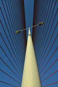 Low angle view of suspension bridge against clear blue sky