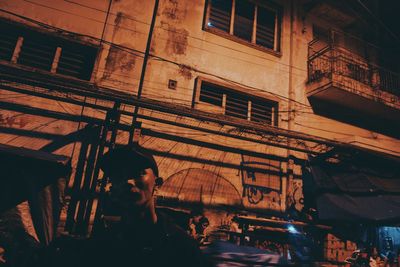 Man sitting in illuminated building at night