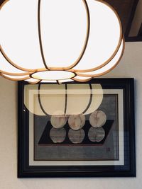 Close-up of illuminated electric lamp on wall at home