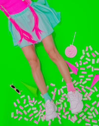 Low section of woman with text on paper over green background