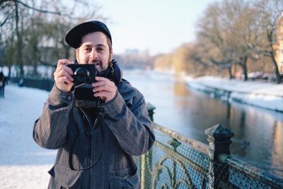 Portrait of man photographing in snow