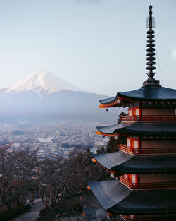 Pagoda in city against clear sky