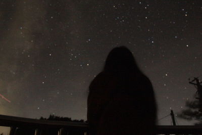 Silhouette man standing against sky at night