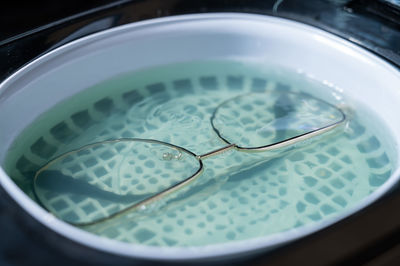 High angle view of wet glass in container