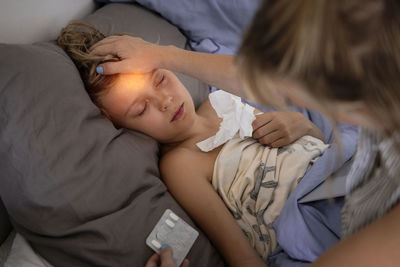 Mother applying medicine to sick boy