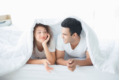 Friends relaxing on bed