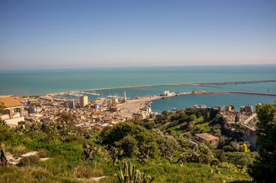 High angle view of city by sea against clear sky