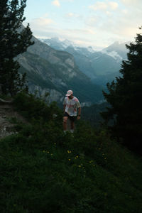 Man hiking in the mountains of switzerland in blue hour just after sunset. shot on fujifilm x100v.