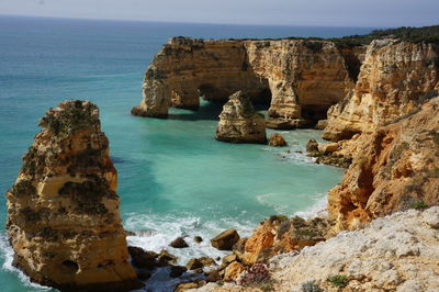 Scenic view of rock formation by sea against sky