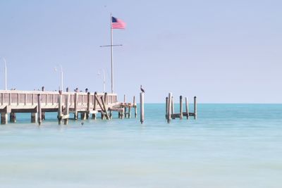 Wooden posts on beach against clear sky