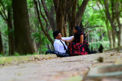 Surface level view of couple sitting at park