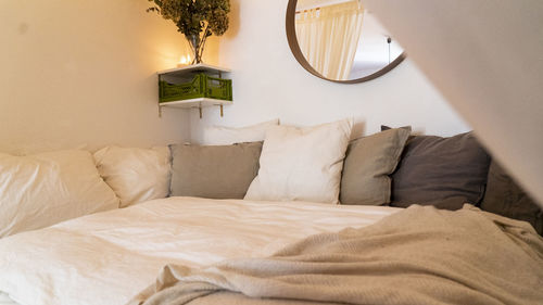 Cushions arranged on bed at home