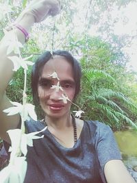 Portrait of young woman wearing sunglasses against plants